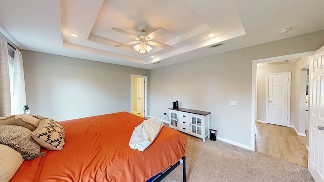 carpeted bedroom with visible vents, baseboards, ceiling fan, recessed lighting, and a raised ceiling