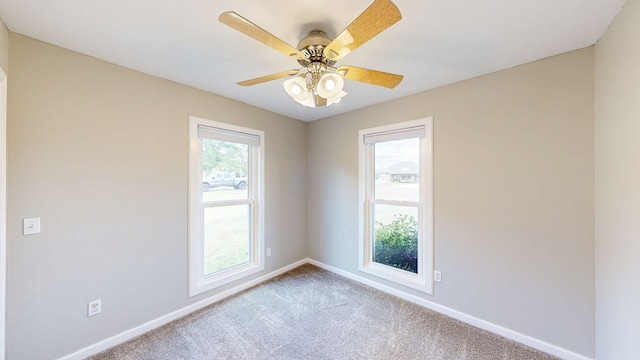 carpeted empty room featuring baseboards and a ceiling fan