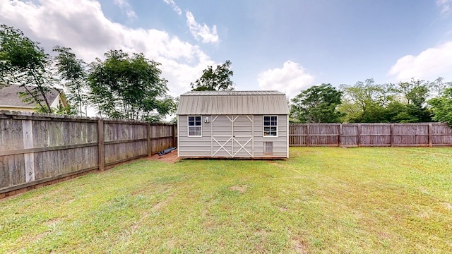 view of yard with a fenced backyard, a storage unit, and an outdoor structure