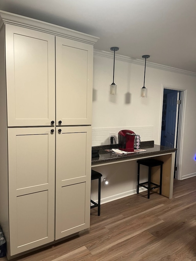 16 Holman St, Daleville, AL 36322 - kitchen featuring ornamental molding, dark wood-style flooring, a breakfast bar, decorative light fixtures, and an office area