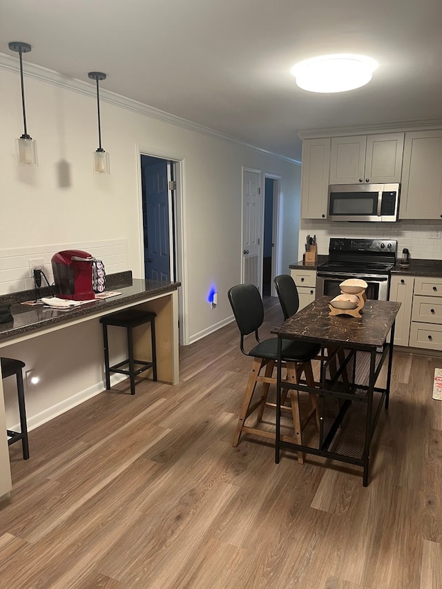16 Holman St, Daleville, AL 36322 - kitchen with stainless steel appliances, dark countertops, crown molding, backsplash, and dark wood-type flooring