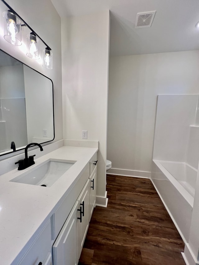 bathroom with vanity, toilet, and hardwood / wood-style floors