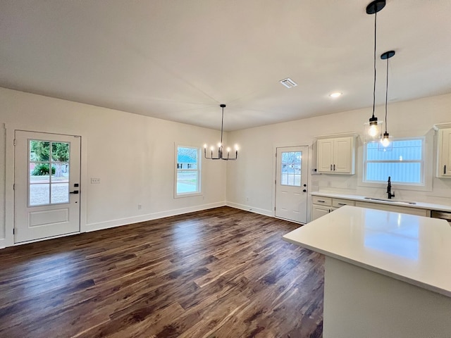 kitchen featuring pendant lighting, dark hardwood / wood-style floors, sink, and white cabinets