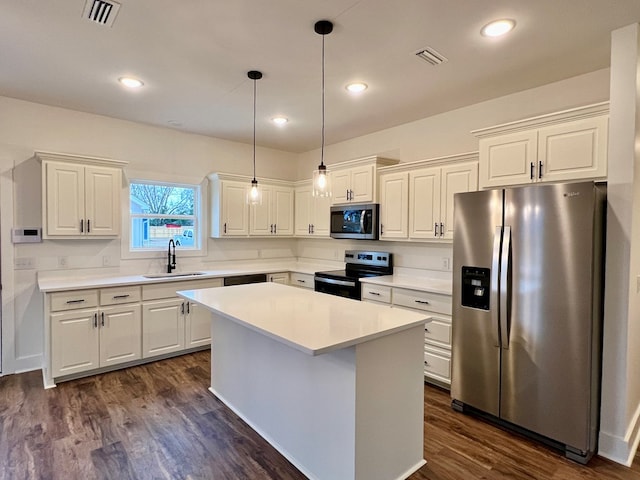 kitchen with sink, a center island, appliances with stainless steel finishes, dark hardwood / wood-style flooring, and pendant lighting