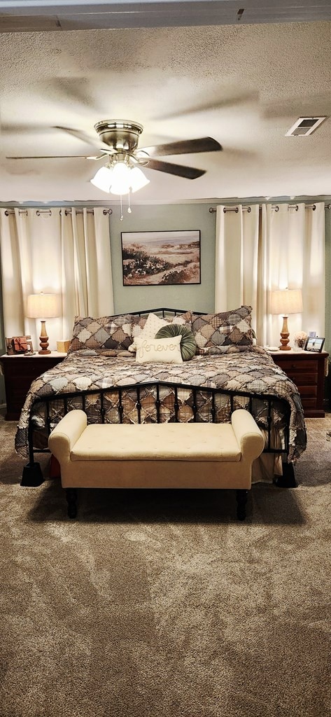207 W Pullum St, Samson, AL 36477 - carpeted bedroom featuring a textured ceiling and a ceiling fan