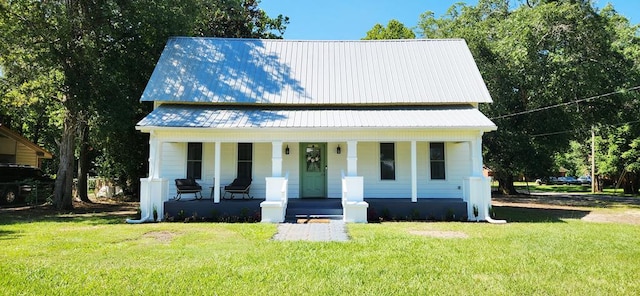 207 W Pullum St, Samson, AL 36477 - view of front of house with a porch, a front lawn, and a metal roof