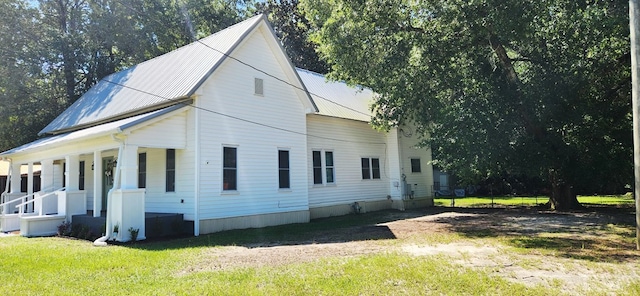 207 W Pullum St, Samson, AL 36477 - view of front facade featuring covered porch, a front yard, and a metal roof