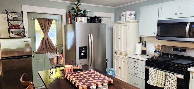 207 W Pullum St, Samson, AL 36477 - kitchen with stainless steel appliances, ornamental molding, light countertops, white cabinets, and tasteful backsplash