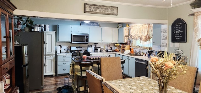 207 W Pullum St, Samson, AL 36477 - kitchen with stainless steel appliances, ornamental molding, light countertops, dark wood-type flooring, and white cabinets