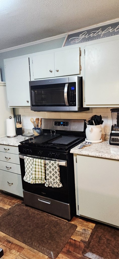 207 W Pullum St, Samson, AL 36477 - kitchen featuring appliances with stainless steel finishes, white cabinets, a textured ceiling, and dark wood-type flooring