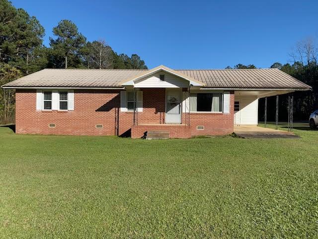 view of front facade with a front lawn and a carport