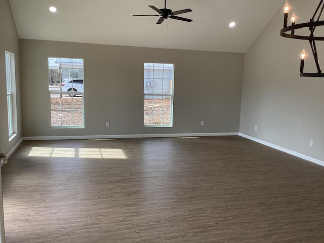 empty room with a healthy amount of sunlight, lofted ceiling, and dark wood-type flooring