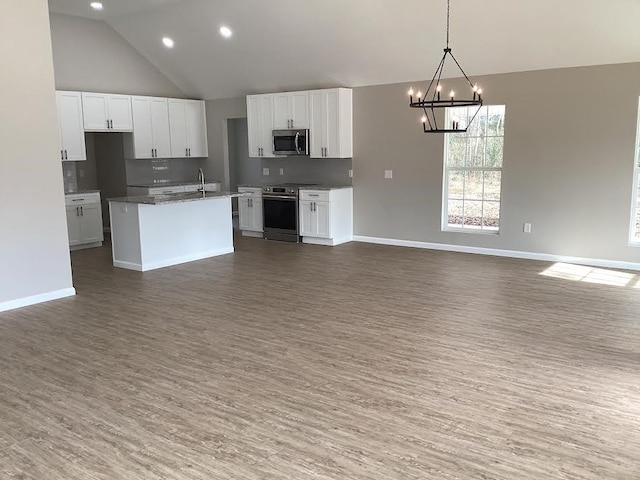 kitchen featuring stainless steel appliances, white cabinetry, and a kitchen island with sink