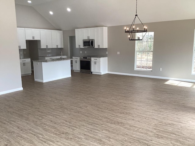 kitchen with stainless steel appliances, a kitchen island with sink, and white cabinets