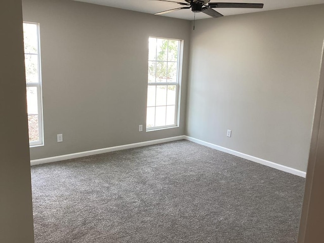 unfurnished room with ceiling fan and dark colored carpet