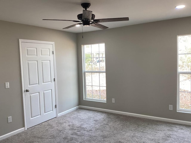 carpeted spare room with ceiling fan