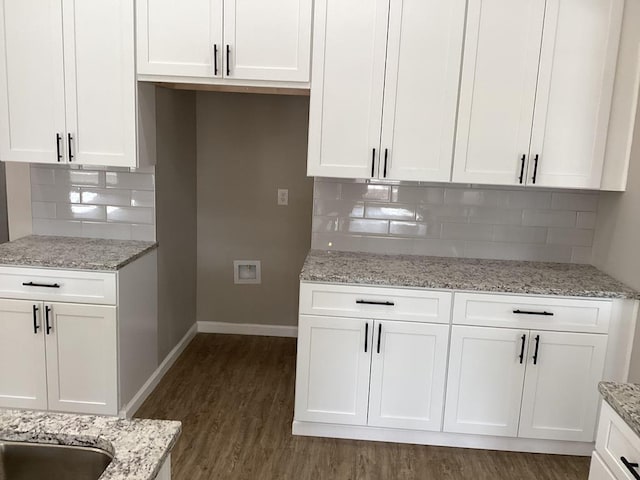 kitchen featuring white cabinetry, light stone countertops, backsplash, and dark hardwood / wood-style flooring