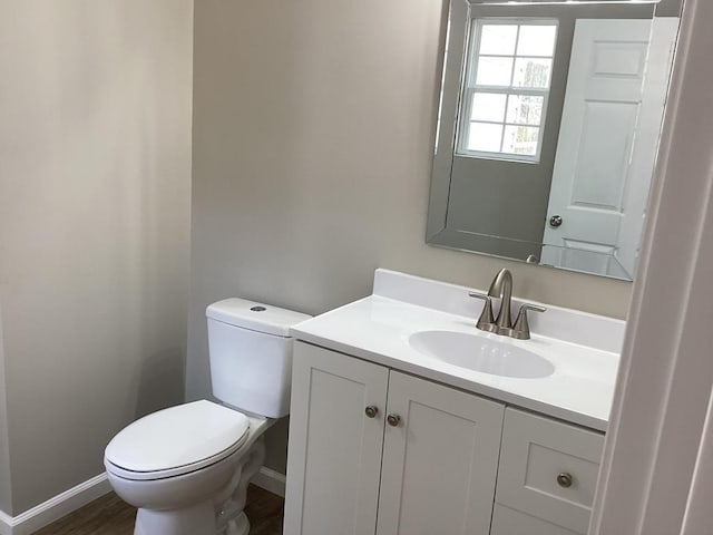 bathroom featuring vanity, toilet, and hardwood / wood-style floors