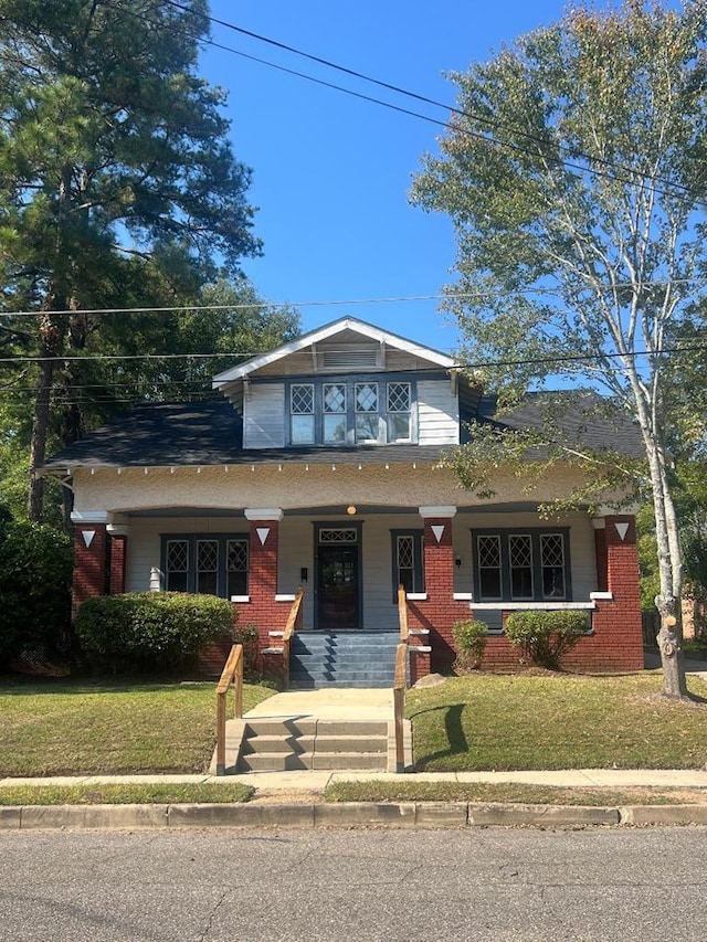 view of front of property with covered porch and a front lawn