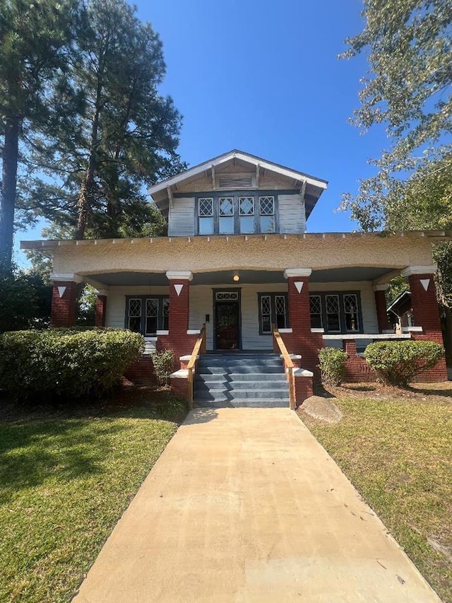 view of front facade with covered porch and a front lawn