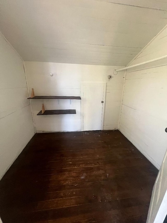 spare room with dark hardwood / wood-style floors and lofted ceiling