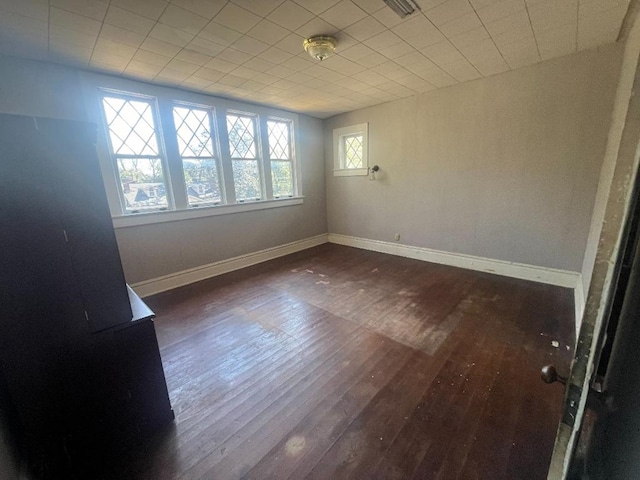 unfurnished room with dark hardwood / wood-style flooring