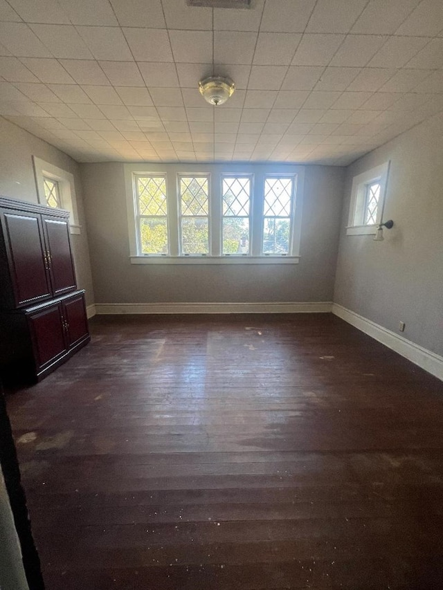 empty room featuring dark hardwood / wood-style flooring and a healthy amount of sunlight