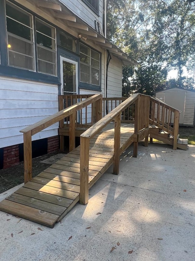 wooden deck featuring a patio area and a storage shed