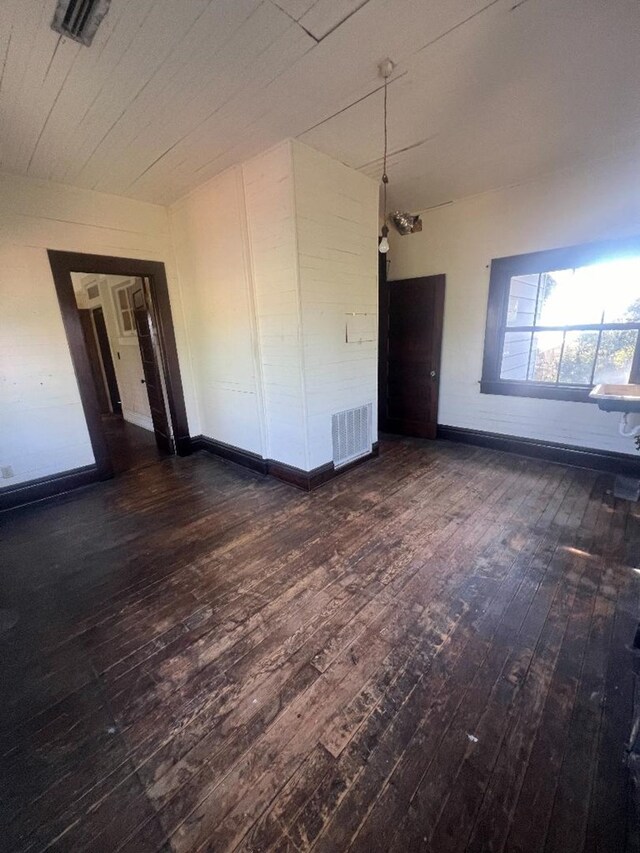 unfurnished room with dark hardwood / wood-style flooring and an inviting chandelier