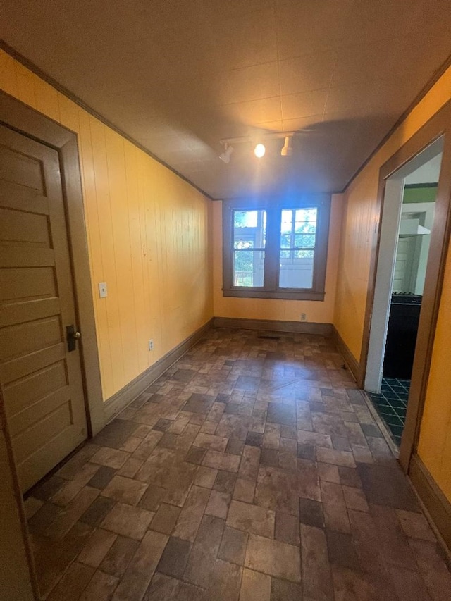 unfurnished room featuring wood walls