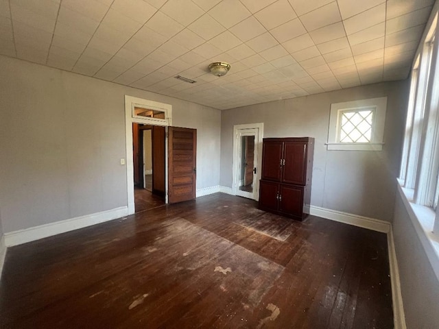 unfurnished bedroom with dark hardwood / wood-style flooring