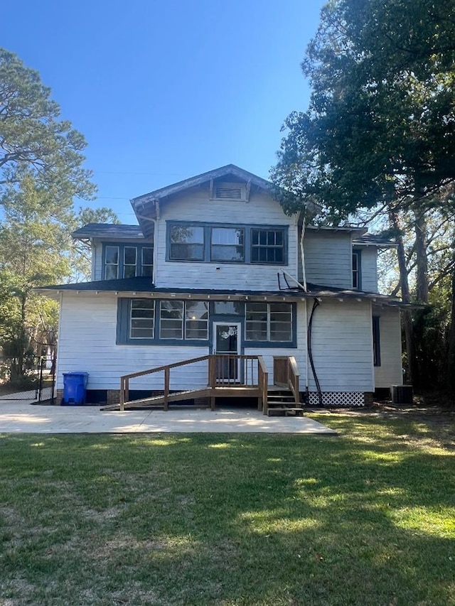 rear view of house with a lawn and cooling unit