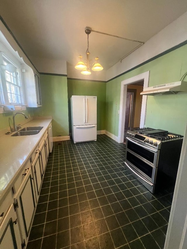 kitchen with range with two ovens, sink, range hood, white fridge, and a chandelier