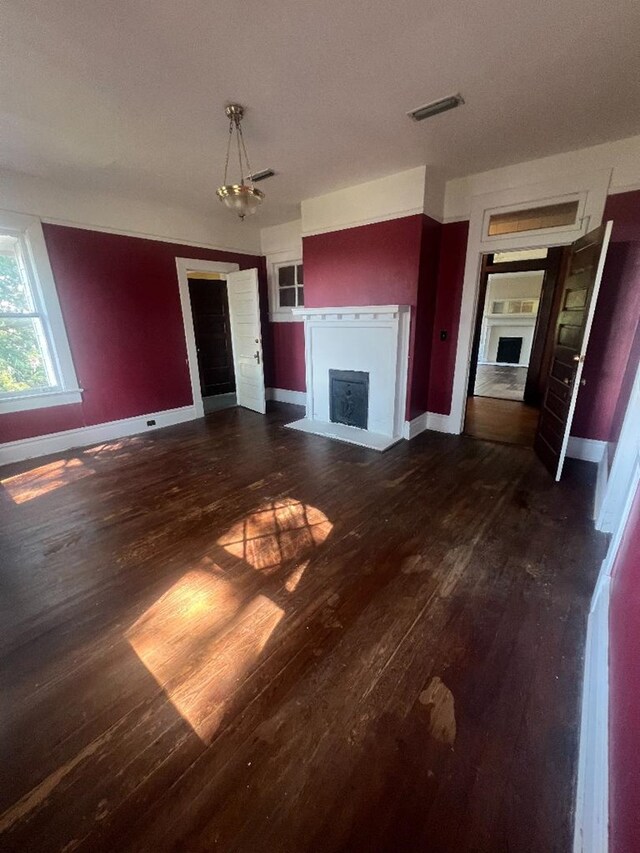 unfurnished living room featuring dark hardwood / wood-style flooring and a notable chandelier