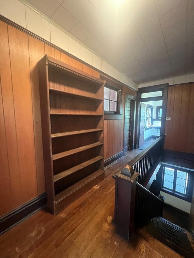 staircase featuring wooden walls and hardwood / wood-style floors