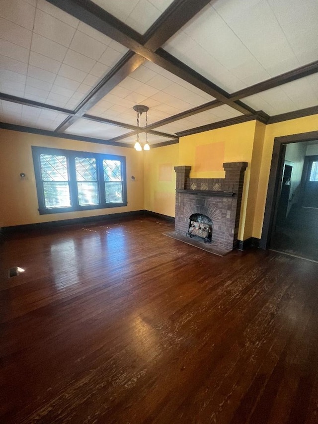 unfurnished living room with beam ceiling, a stone fireplace, and dark wood-type flooring