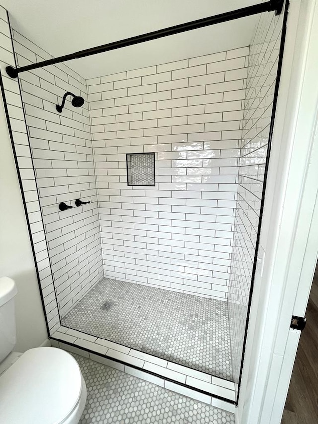 full bath with toilet and a stall shower