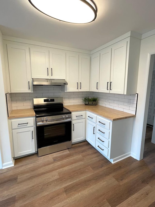 kitchen with under cabinet range hood, electric range, butcher block countertops, and light wood-style floors