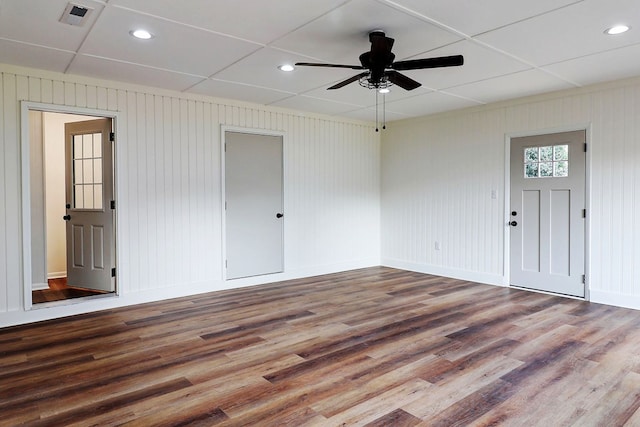 spare room with a ceiling fan, wood finished floors, visible vents, and baseboards