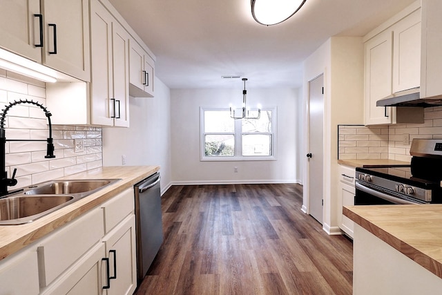 kitchen with dark wood finished floors, stainless steel appliances, a sink, butcher block countertops, and under cabinet range hood