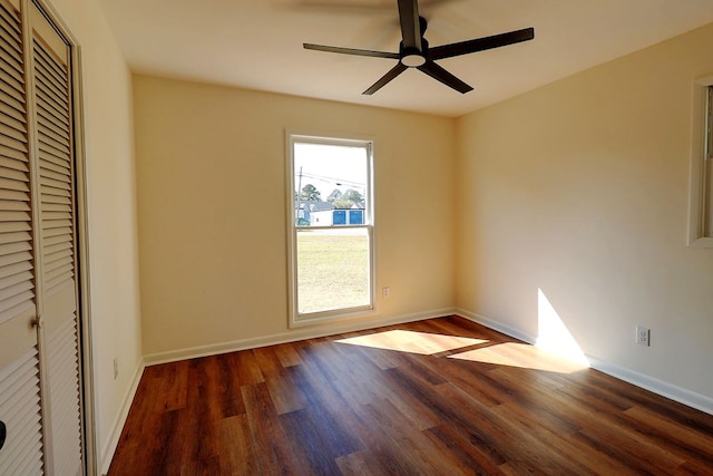 unfurnished bedroom featuring a ceiling fan, a closet, baseboards, and wood finished floors