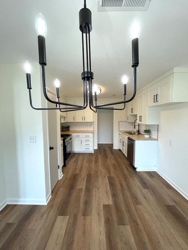 kitchen featuring tasteful backsplash, visible vents, dishwasher, gas range oven, and a sink