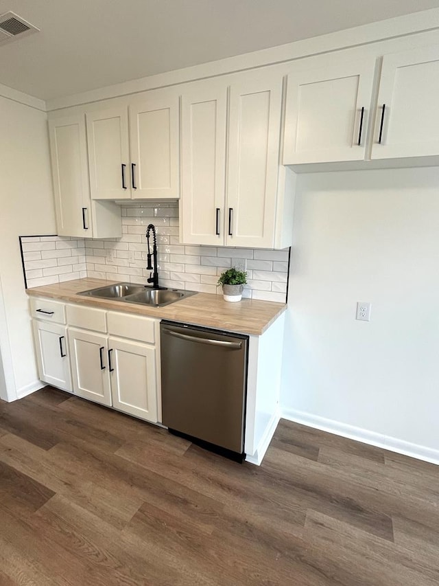 kitchen with dishwasher, tasteful backsplash, a sink, and white cabinets