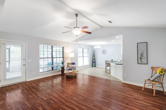 living area featuring a ceiling fan, light wood-style floors, a chandelier, and baseboards