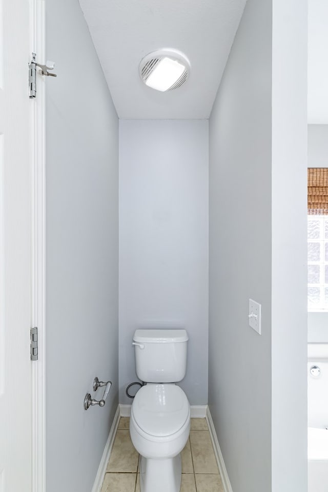 bathroom with toilet, tile patterned floors, and baseboards