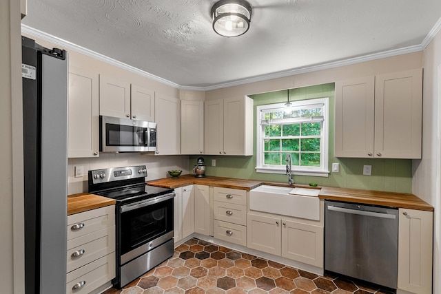 1906 Sullivan Dr, Dothan, AL 36303 - kitchen with butcher block countertops, appliances with stainless steel finishes, a sink, and crown molding