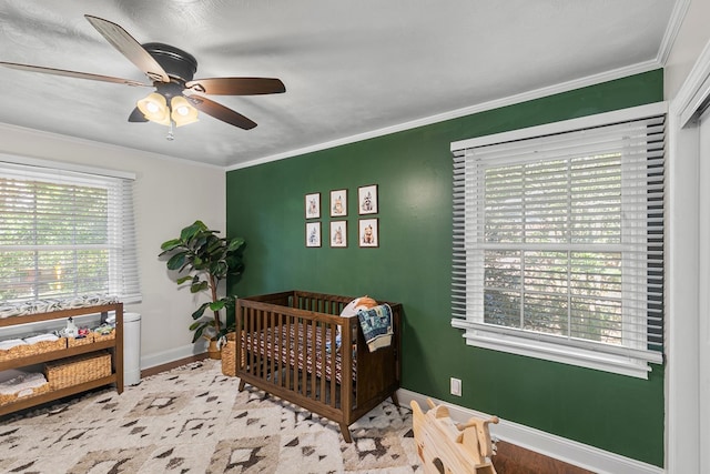 1906 Sullivan Dr, Dothan, AL 36303 - bedroom with baseboards, ornamental molding, a nursery area, ceiling fan, and wood finished floors