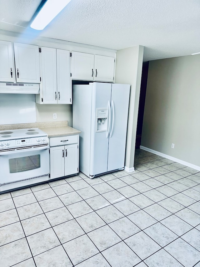 kitchen featuring white cabinets, light tile patterned flooring, white appliances, and a textured ceiling