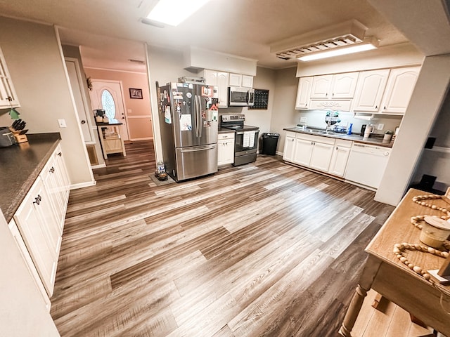 178 W Lawrence Harris Hwy, Slocomb, AL 36375 - kitchen featuring appliances with stainless steel finishes, dark countertops, white cabinets, and light wood-style floors