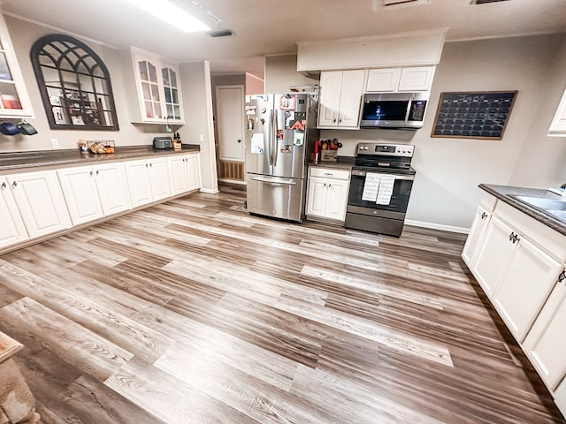 178 W Lawrence Harris Hwy, Slocomb, AL 36375 - kitchen with appliances with stainless steel finishes, dark countertops, glass insert cabinets, and white cabinets